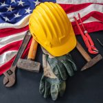 Labor Day concept. American flag and construction tools on dark background, above view. USA holiday celebration